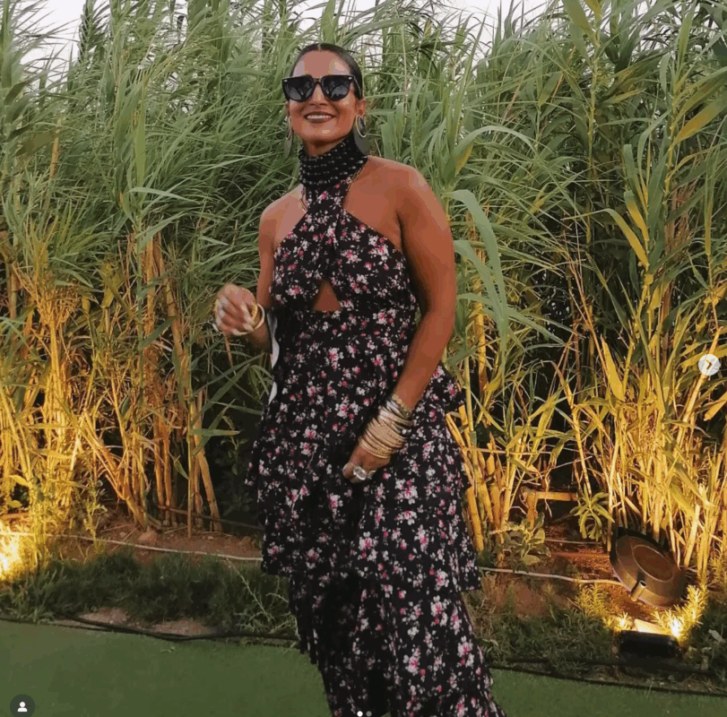 Ελένα με καλοκαιρινό outfit με τσόκερ και floral φόρμα σε κήπο.