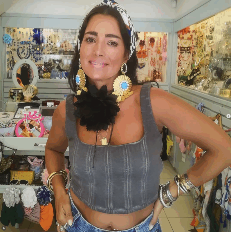 At-home glam look με εντυπωσιακά κοσμήματα, μάξι σκουλαρίκια και μπότες σε minimal σαλόνι.