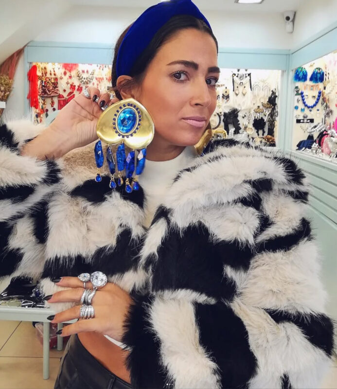 Γυναίκα με μπλε στέκα, ασπρόμαυρη γούνα και τεράστια χρυσά σκουλαρίκια με μπλε κρύσταλλα και κρεμαστά στοιχεία