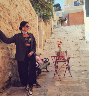 Ναύπλιο για 3ήμερο Το Ναύπλιο είναι το ιδανικό 3ήμερο γιατί σε αφήνει να κάνεις το πιο ωραίο mix: πρωινό περπάτημα στα στενά, απογευματινό καφέ με θέα και βραδινό κρασί σε μια αυλή που μυρίζει γιασεμί. Και κάπου εκεί μπαίνει το αγαπημένο μου παιχνίδι: πώς φτιάχνεις βαλίτσα “λίγα αλλά δυνατά” και πώς αφήνεις τα κοσμήματα να κάνουν αυτό που ξέρουν καλύτερα — να ανεβάζουν το look χωρίς να κουβαλάς μισή ντουλάπα. Η capsule βαλίτσα για Ναύπλιο: 9 κομμάτια ρούχα + 6 κοσμήματα Αν θες να βγεις ασπροπρόσωπη σε κάθε περίσταση (βόλτα, καφέ, δείπνο), πάμε με μια capsule λογική: ✦ Ρούχα: 1 blazer ή trench, 1 τζιν, 1 μαύρο παντελόνι ή δερμάτινη φούστα, 1 φόρεμα (μαύρο ή printed), 2 tops (ένα basic, ένα “wow”), 1 πλεκτό/ζακέτα, 1 πουκάμισο, 1 ζευγάρι άνετα παπούτσια + 1 ζευγάρι “βραδινά”. ✦ Κοσμήματα (capsule): ένα δυνατό ζευγάρι Σκουλαρίκια, ένα statement Κολλιέ, ένα choker (ή κορδέλα-κολιέ), 2-3 stackable Βραχιόλια, και 2 “ήρωες” σε Δαχτυλίδια (ένα chunky + ένα πιο λεπτό). Double Trouble tip: Σε ταξίδι 3 ημερών δεν θες “πολλά ίδια”. Θες κομμάτια που αλλάζουν ρόλο: τα ίδια σκουλαρίκια να δουλεύουν και με τζιν το πρωί και με φόρεμα το βράδυ. Day 1 – Άφιξη & παλιά πόλη: το “άνετο αλλά φωτογενές” look Μόλις φτάσεις, θες κάτι που να σε αφήνει να περπατήσεις, να κάτσεις για καφέ και να βγεις φωτογραφία χωρίς να νιώθεις “τουρίστρια με φόρμα”. ✦ Outfit: τζιν ή μαύρο παντελόνι + basic top + blazer/trench. ✦ Κοσμήματα: κράτα το πάνω μέρος “καθαρό” και δώσε ένταση κοντά στο πρόσωπο με ένα ζευγάρι statement Σκουλαρίκια. Στους καρπούς, 2-3 Βραχιόλια για να “γράφουν” όταν κρατάς καφέ/κινητό/τσάντα. Αυτό είναι το πιο εύκολο styling hack για φωτογραφίες στα στενά. Το λάθος που κάνουμε στο city break Φοράμε “όλα τα άνετα” και ξεχνάμε το σημείο-κλειδί: ένα statement. Μετά οι φωτογραφίες βγαίνουν “οκ” αλλά όχι “wow”. Πώς το διορθώνεις: διάλεξε ένα δυνατό στοιχείο (σκουλαρίκι ή κολιέ) και άσε τα υπόλοιπα να το στηρίζουν. Day 2 – Παλαμήδι, βόλτα & δείπνο: από πρωινό σε βραδινό χωρίς αλλαγή βαλίτσας Η δεύτερη μέρα θέλει “διπλή ζωή”: περπάτημα/θέα/αέρας και μετά βράδυ με κρασί. Εδώ η λύση είναι το layering στα κοσμήματα. ✦ Outfit: φόρεμα (printed ή μαύρο) ή total black με μια ζακέτα/blazer. ✦ Πρωί: μικρότερο κολιέ ή λεπτό layering, πιο “ήσυχα” βραχιόλια. ✦ Βράδυ: πρόσθεσε choker + ένα πιο μακρύ Κολλιέ και ανέβασε τα Δαχτυλίδια (ένα chunky κάνει όλη τη δουλειά). Το αποτέλεσμα είναι “έτοιμη για δείπνο” χωρίς να αλλάξεις ρούχο. Double Trouble tip: Αν φυσάει (και στο Ναύπλιο φυσάει), προτίμησε σκουλαρίκια που “κάθονται” καλά και ένα choker που σταθεροποιεί το styling. Δεν θες να παλεύεις με τα μαλλιά σου κάθε 2 λεπτά. Day 3 – Brunch & τελευταίες φωτογραφίες: το “soft αλλά με προσωπικότητα” look Την τρίτη μέρα συνήθως είμαστε πιο χαλαρές, αλλά θέλουμε να φύγουμε με ωραίες φωτογραφίες. Άρα: πιο light ρούχο, πιο “έξυπνο” κόσμημα. ✦ Outfit: πουκάμισο + τζιν/παντελόνι ή ένα φόρεμα σε άνετη γραμμή. ✦ Κοσμήματα: ένα ζευγάρι statement Σκουλαρίκια + 2 λεπτές αλυσίδες. Και τέλος. Το βλέμμα ανεβαίνει στο πρόσωπο, το look φαίνεται “φροντισμένο”, αλλά δεν δείχνει στημένο. Ο μικρός οδηγός κοσμημάτων για ταξίδι: τι να πάρεις για να μην μπερδευτείς ✦ Κανόνας 1: Διάλεξε 1 “πρωταγωνιστή” (σκουλαρίκι ή κολιέ). Όλα τα άλλα είναι supporting cast. ✦ Κανόνας 2: Κράτα μία σταθερή “βάση” μετάλλου (π.χ. χρυσό ή ασημί) και παίξε με υφές. ✦ Κανόνας 3: Δαχτυλίδια σε ζευγάρια: ένα chunky, ένα λεπτό. Έτσι δεν ψάχνεις “τι ταιριάζει”. ✦ Κανόνας 4: Τα βραχιόλια είναι το πιο travel-friendly statement — δεν σε πιέζουν, δεν “φωνάζουν” και γράφουν τέλεια στις κινήσεις. Κλείσιμο – Ναύπλιο σημαίνει ρομαντισμός, αλλά εσύ φέρνεις το attitude Το Ναύπλιο για 3ήμερο δεν θέλει υπερπροσπάθεια. Θέλει σωστή επιλογή: δύο καλά outfits και κοσμήματα που “μιλάνε” για σένα. Γιατί το πιο δυνατό styling δεν είναι το πιο ακριβό — είναι αυτό που σε κάνει να περπατάς στα στενά και να λες “ναι, αυτό είμαι”. Ακολούθησέ με: 📷 Instagram: @doubletrouble.gr 🎵 TikTok: @doubletrouble.gr 🌐 Website: www.doubletrouble.gr Αν θες να σου φτιάξω capsule κοσμημάτων για το επόμενο 3ήμερό σου, στείλε μου DM και το στήνουμε μαζί.