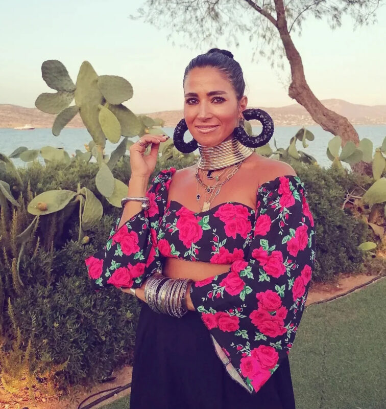 Ελένα με εντυπωσιακά μεγάλα μπιζού, floral top, statement σκουλαρίκια και δυνατό τσόκερ δίπλα στη θάλασσα.