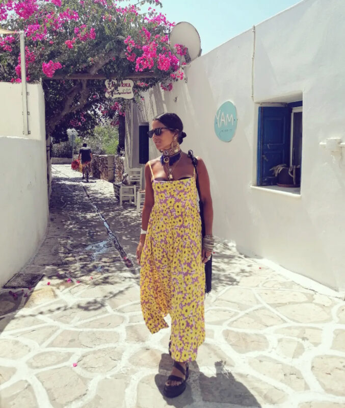 Στενά σοκάκια σε νησί με floral ολόσωμο, τσόκερ, μεγάλα σκουλαρίκια και βραχιόλια κάτω από μπουκαμβίλιες.