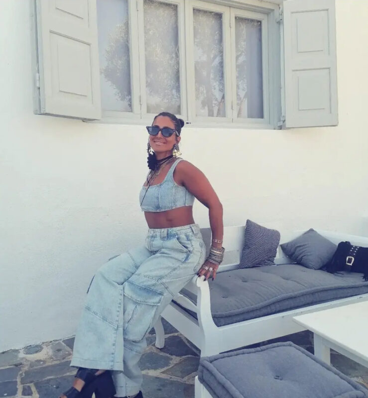 Γυναίκα με denim top και φαρδύ denim παντελόνι, statement τσόκερ, layered κολιέ, μεγάλα σκουλαρίκια και πολλά βραχιόλια.