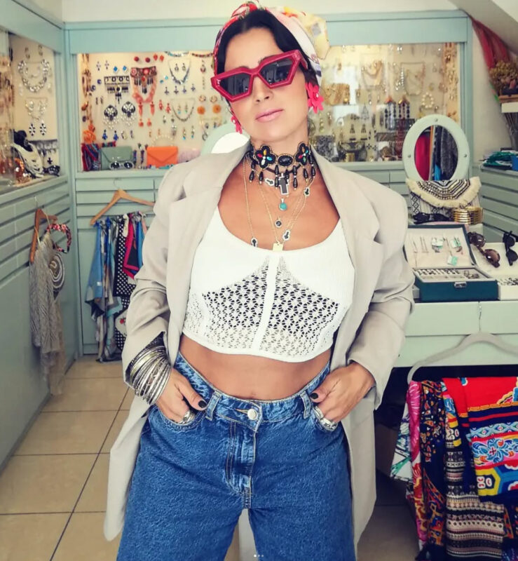 Γυναίκα με jeans, λευκό crop top, blazer, statement τσόκερ, layered κολιέ, μαντήλι και έντονα γυαλιά σε day to night maximal look.